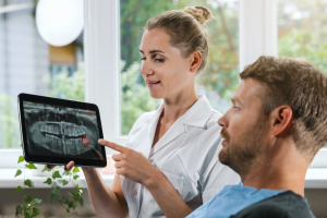 Dentist explaining an impacted wisdom tooth X-ray to a patient