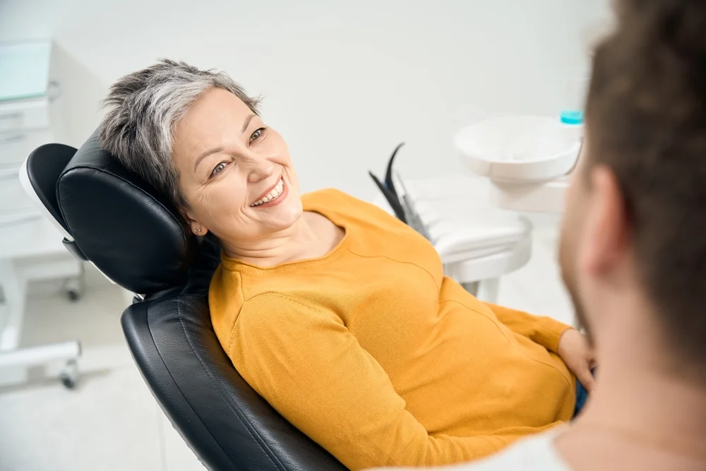 Woman in dental chair looking at dentist