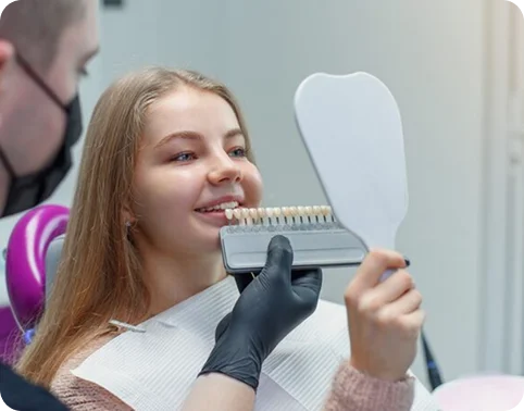 Patient comparing tooth shades with a dentist.